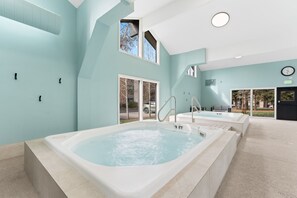 A spa area with two hot tubs, a view of the outside, and a clock on the wall. - Steps from Lake Dillon & Amphitheater - Central to 3 World-Class Ski Resorts! (Dillon)