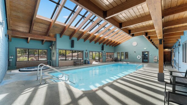 A swimming pool with a wooden ceiling and large windows. - Modern Mountain-View Condo - Pool, Hot Tubs & Near 3 Ski Resorts! (Frisco)