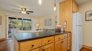 A kitchen with wooden cabinets, a black countertop, and a white refrigerator.