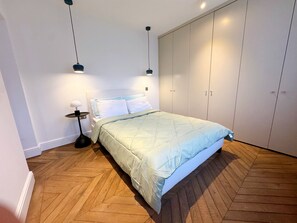 2 habitaciones, escritorio y tabla de planchar con plancha