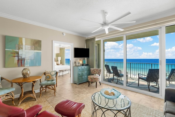 A spacious balcony with a view of the beach and ocean.