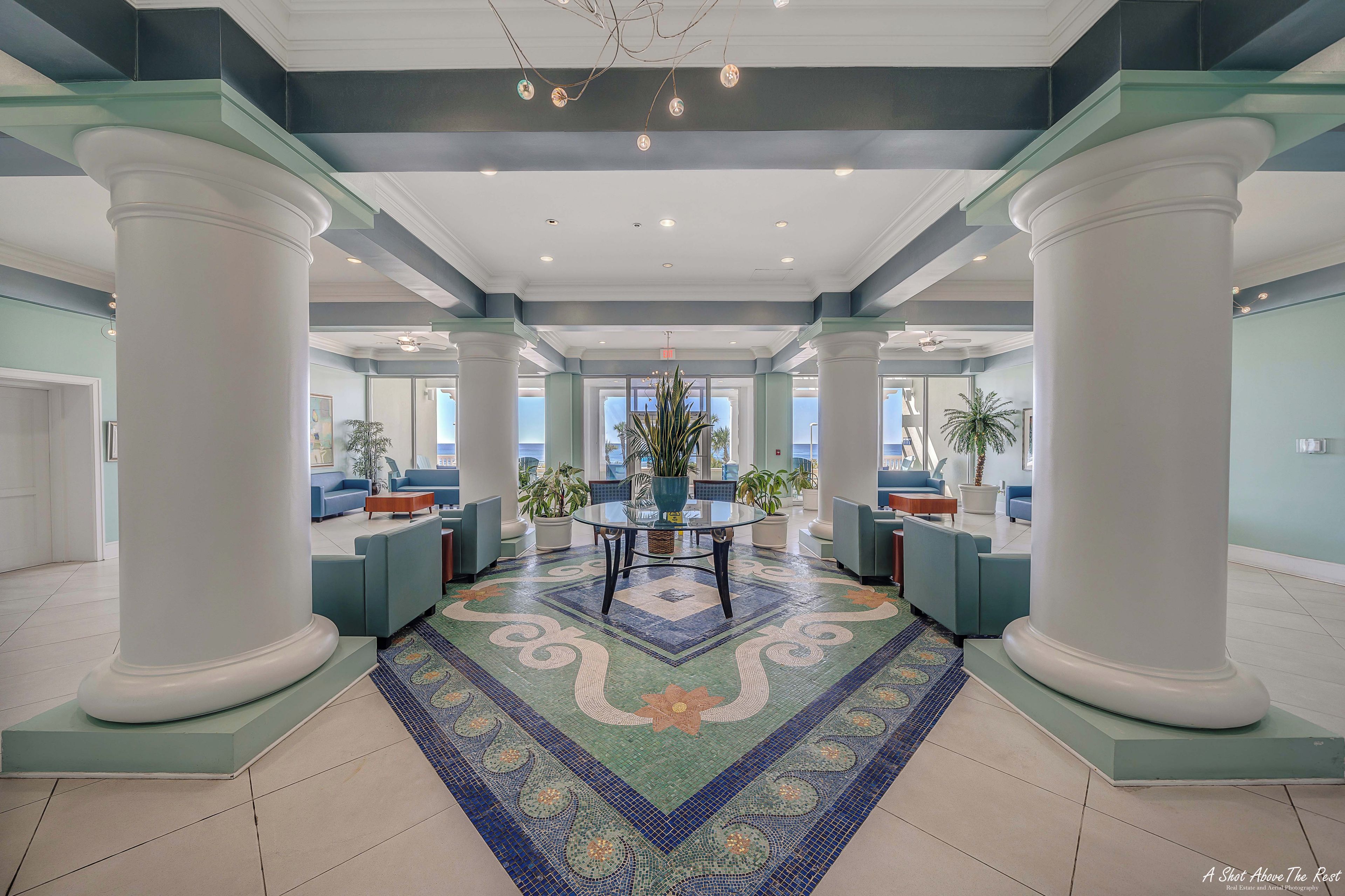 A spacious lobby with a central seating area, large columns, and a patterned floor.
