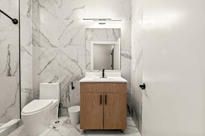 Ein modernes Badezimmer mit Toilette, Waschbecken und Spiegel.