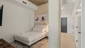 Ein modernes Schlafzimmer mit Bett, Nachttisch und einem Bild an der Wand.