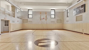 A basketball court with a wooden floor, a basketball hoop, and a scoreboard. - Luxury 4BD | Center City | 5 Beds | By JFK plaza (Philadelphia)