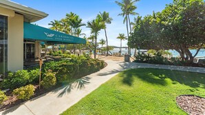 Un restaurante llamado 'Caribbean Fish Market' con terraza, palmeras y vista al mar.
