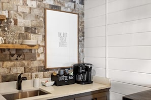 Eine Küche mit Kaffeemaschine, einer Kaffeebar und einem gerahmten Schild an der Wand.