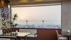 A rooftop terrace with a view of a city skyline, furnished with tables and chairs. - ELITE PARK HOTEL (Jeddah)
