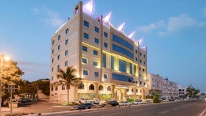 A multi-story hotel with a modern design, featuring a prominent curved facade and illuminated windows. - ELITE PARK HOTEL (Jeddah)