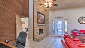 A spacious living room with a fireplace, a ceiling fan, and a red leather couch. - 3 Bedroom with a Pool (Bedford)