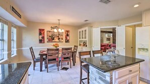 A spacious kitchen with a dining area, featuring a granite countertop, wooden chairs, and a chandelier. - 3 Bedroom with a Pool (Bedford)