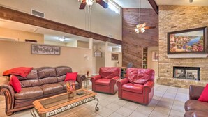 A spacious living room with a leather sofa, red armchairs, a glass coffee table, and a fireplace. - 3 Bedroom with a Pool (Bedford)