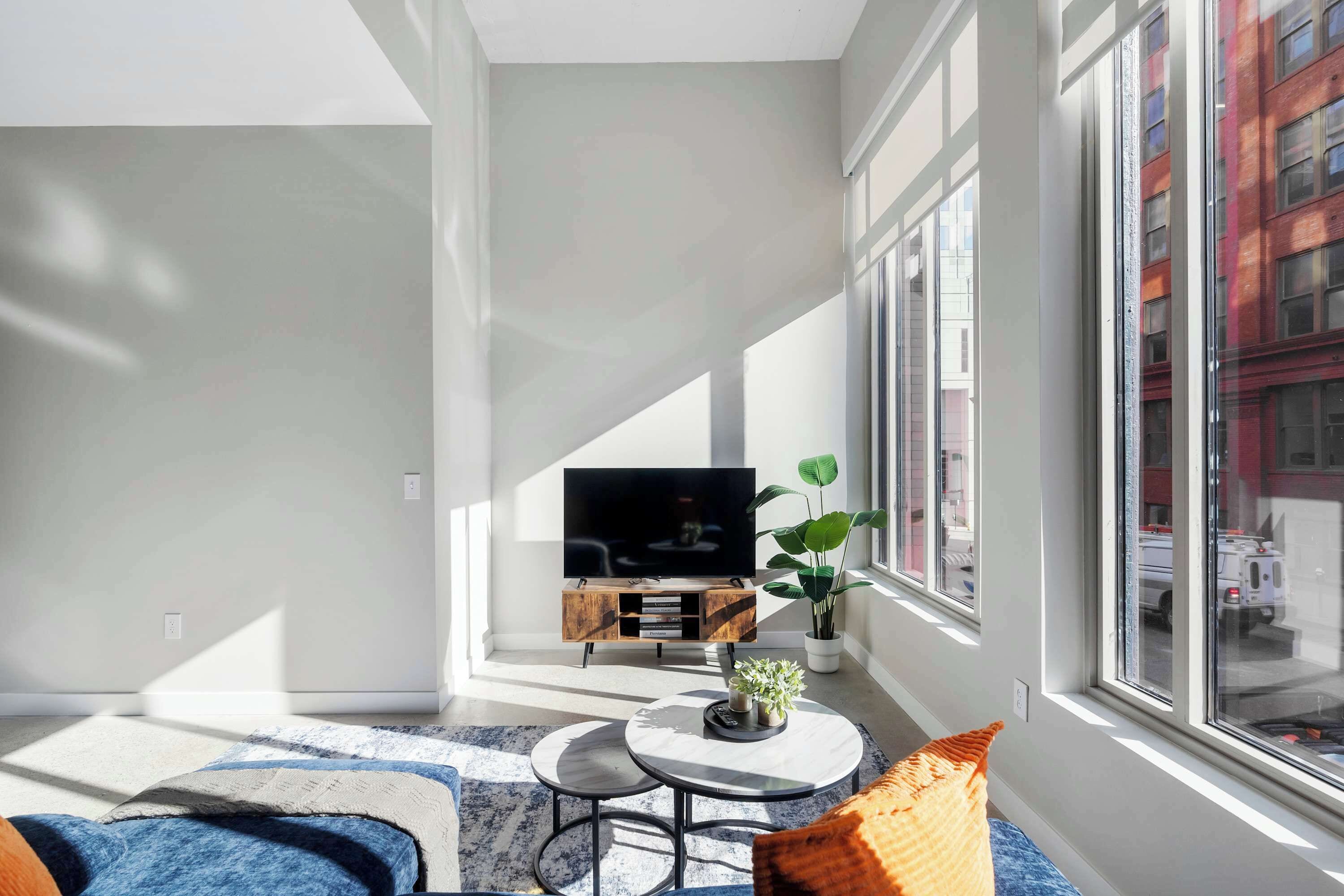A modern living room with a large TV, a coffee table, and a sofa.