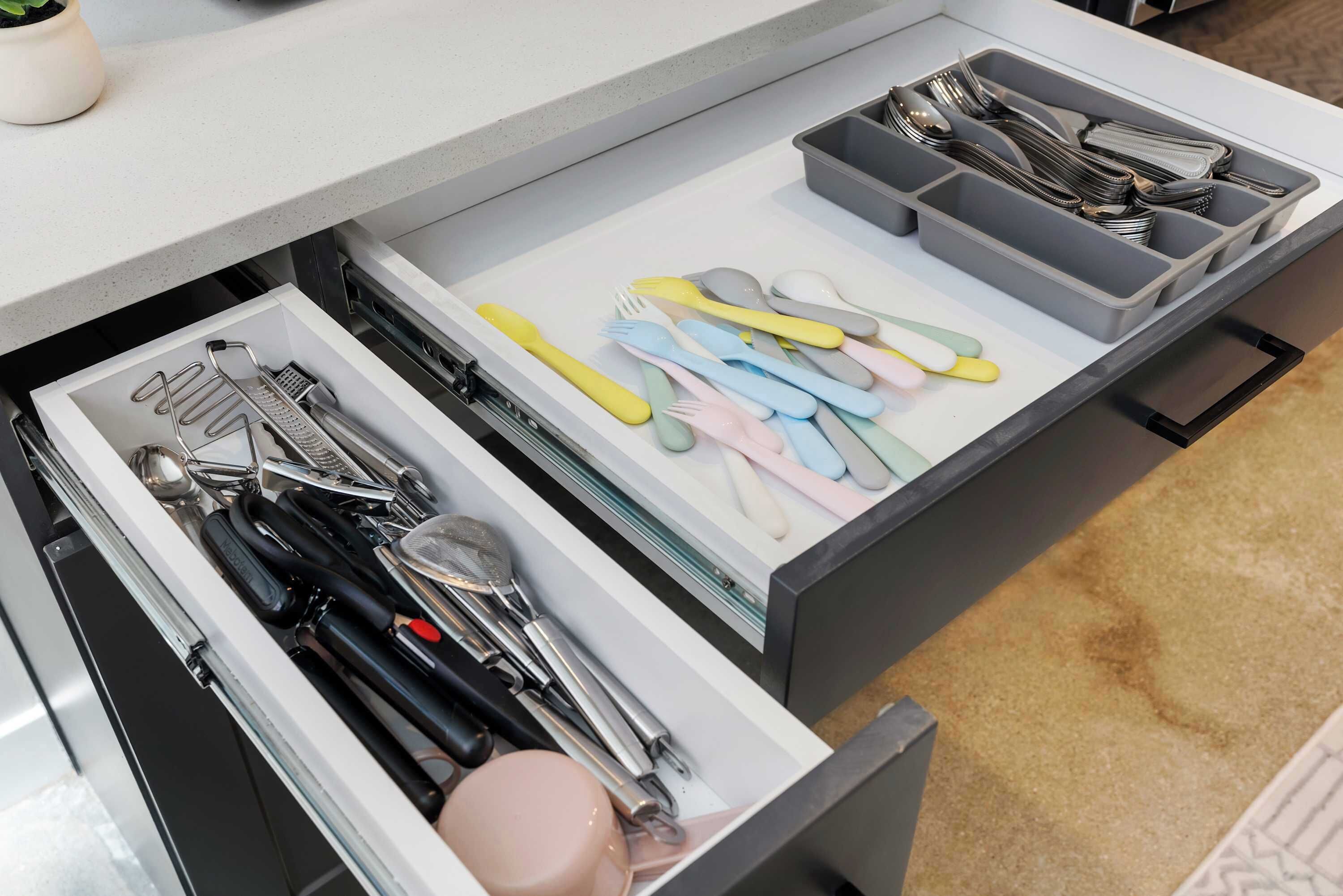 A kitchen drawer with utensils and cookware.