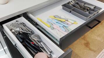 A kitchen drawer with utensils and cookware.
