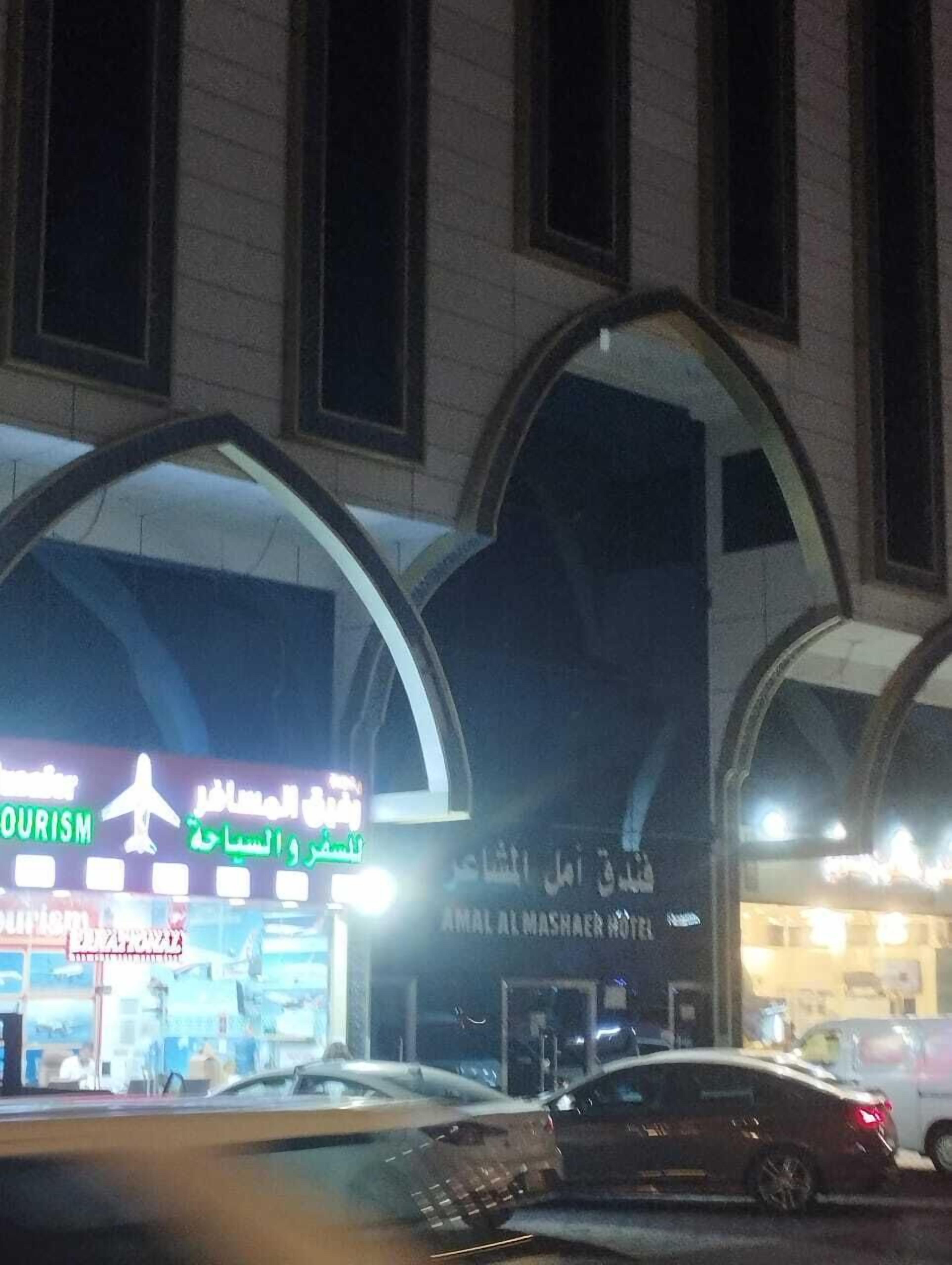 Entrada de un hotel con un cartel que indica que es el Amal Al Mashaer Hotel.