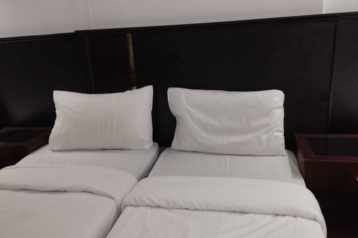 A double bed with white bedding and two nightstands.