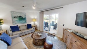 A modern living room with a sofa, coffee table, and a TV.
