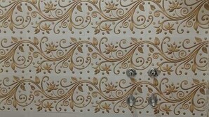 A bathroom with white tiles and decorative floral patterns.