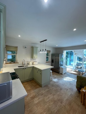 Apartamento família, varanda, vista para o jardim | Cozinha privada | Geladeira grande, micro-ondas, fogão, cooktop
