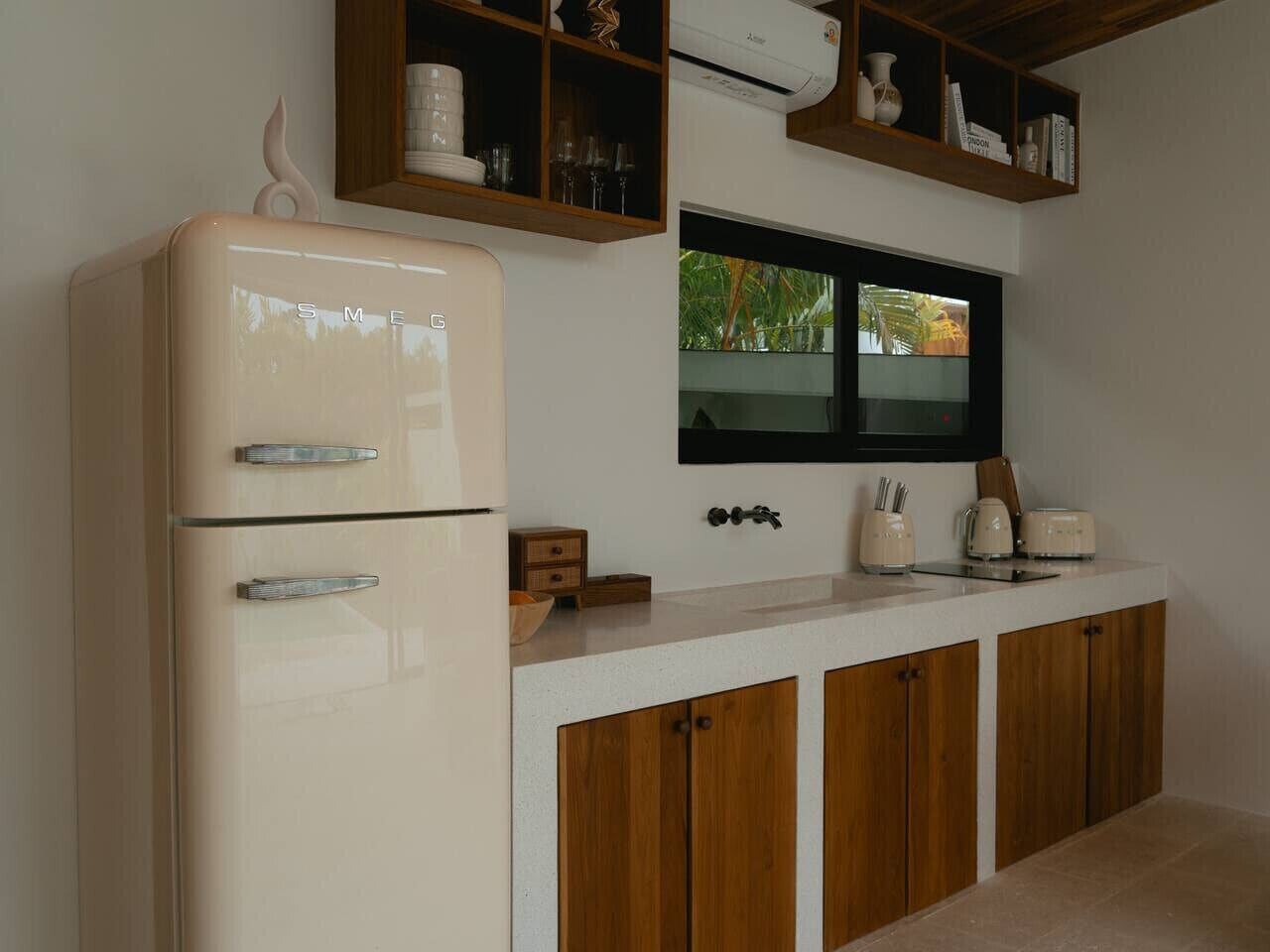 Een koelkast, een broodrooster, kookgerei, borden en bestek, eettafels