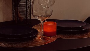 A table set with two wine glasses, a candle, and a decorative basket. - Downtown 1BR Retreat – Walk to PPAC – Kitchen & W/D (Providence)