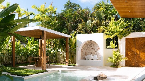 A poolside area with lounge chairs, a covered seating area, and a stone wall with a seating bench. - 1 Bedroom Island Retreat central located (Bo Phut)