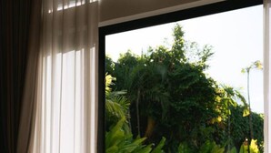 A bedroom with a large window overlooking a pool and lush greenery. - 1 Bedroom Island Retreat central located (Bo Phut)