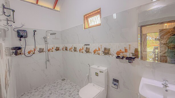 A bathroom with a shower, toilet, and sink. - Blue Water Paradise Akurala (Akurala)