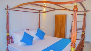 A four-poster bed with a wooden frame and a blue bedspread. - Blue Water Paradise Akurala (Akurala)