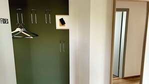 Une pièce avec une porte verte, un plancher en bois et un miroir au mur.