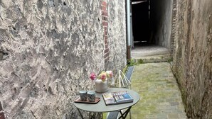 A narrow outdoor seating area with a table, chairs, and a bench. - Spacious family house Elegant 6 pers. 3 *|Center and Quiet - Ste Catherine (Honfleur)