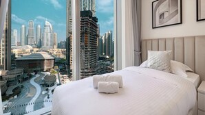 A hotel room with a large bed, a view of a cityscape, and a modern design. - Roomszy Forte Residences Downtown Dubai (Dubai)