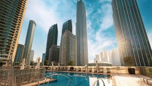 A rooftop pool with a cityscape view, surrounded by high-rise buildings. - Roomszy Forte Residences Downtown Dubai (Dubai)