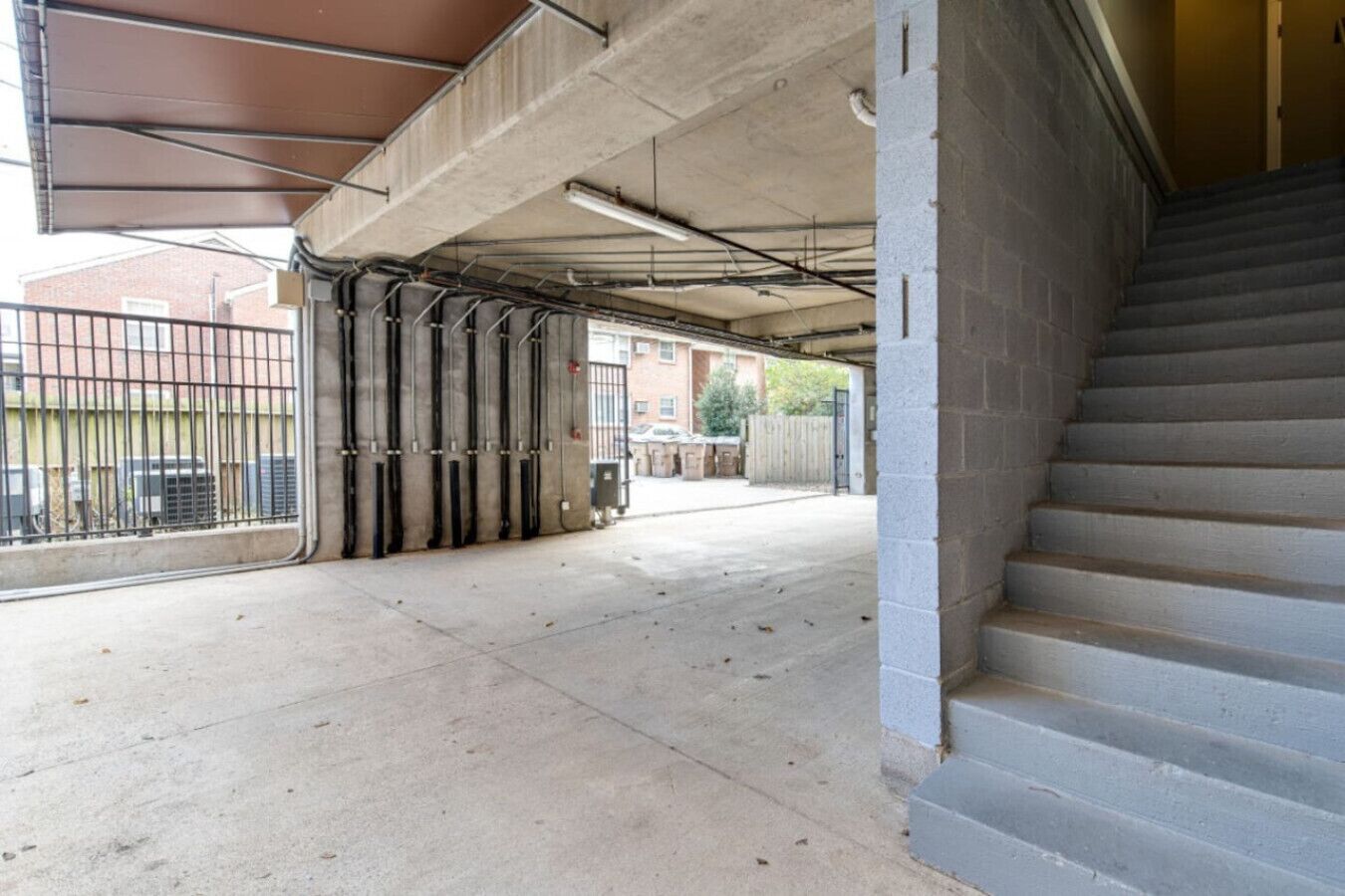 A covered outdoor area with concrete steps leading up to a building entrance.
