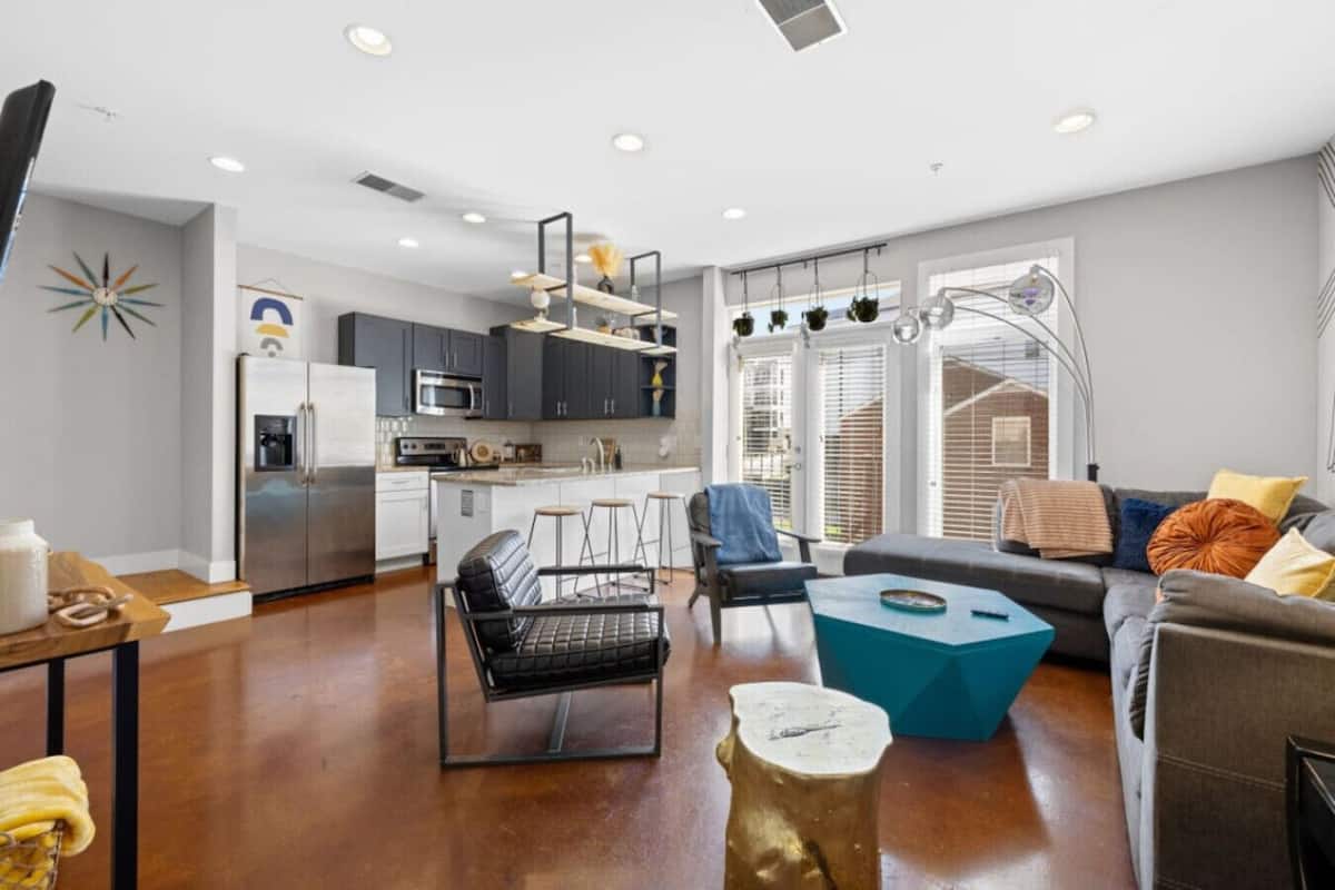 A modern apartment with a kitchen, dining area, and living room.