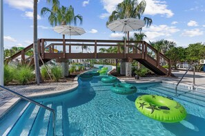 Une piscine avec des bouées gonflables et des palmiers.