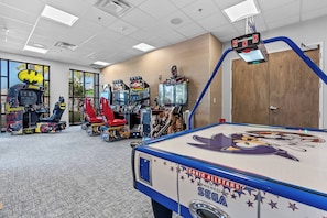 An indoor arcade with various gaming machines, including a pool table with a Sonic the Hedgehog design.