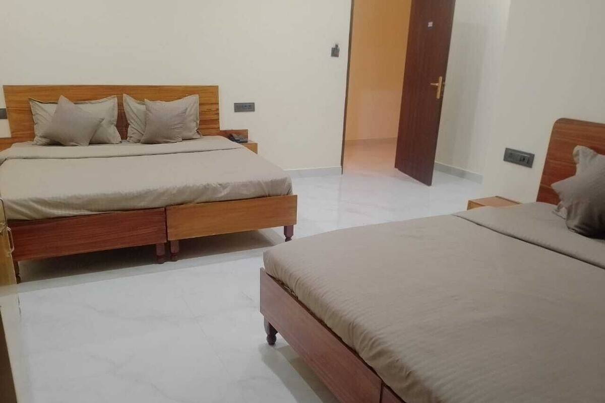 Ein Schlafzimmer mit zwei Holzbetten, einem Kleiderschrank und einer Tür zu einem anderen Raum.