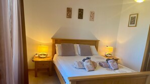 A neatly made bed with pillows and towels, two bedside lamps, and a small table with a lamp. - **Introductory Discount** Gorgeous Apartment with Golf & Pool Views 14132 (Torre-Pacheco)