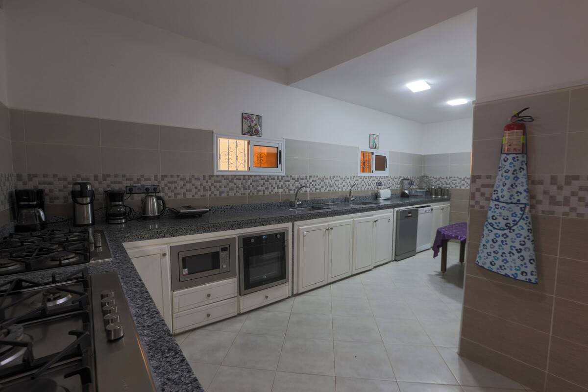 Una cocina moderna equipada con estufa a gas, horno, microondas y cafetera.