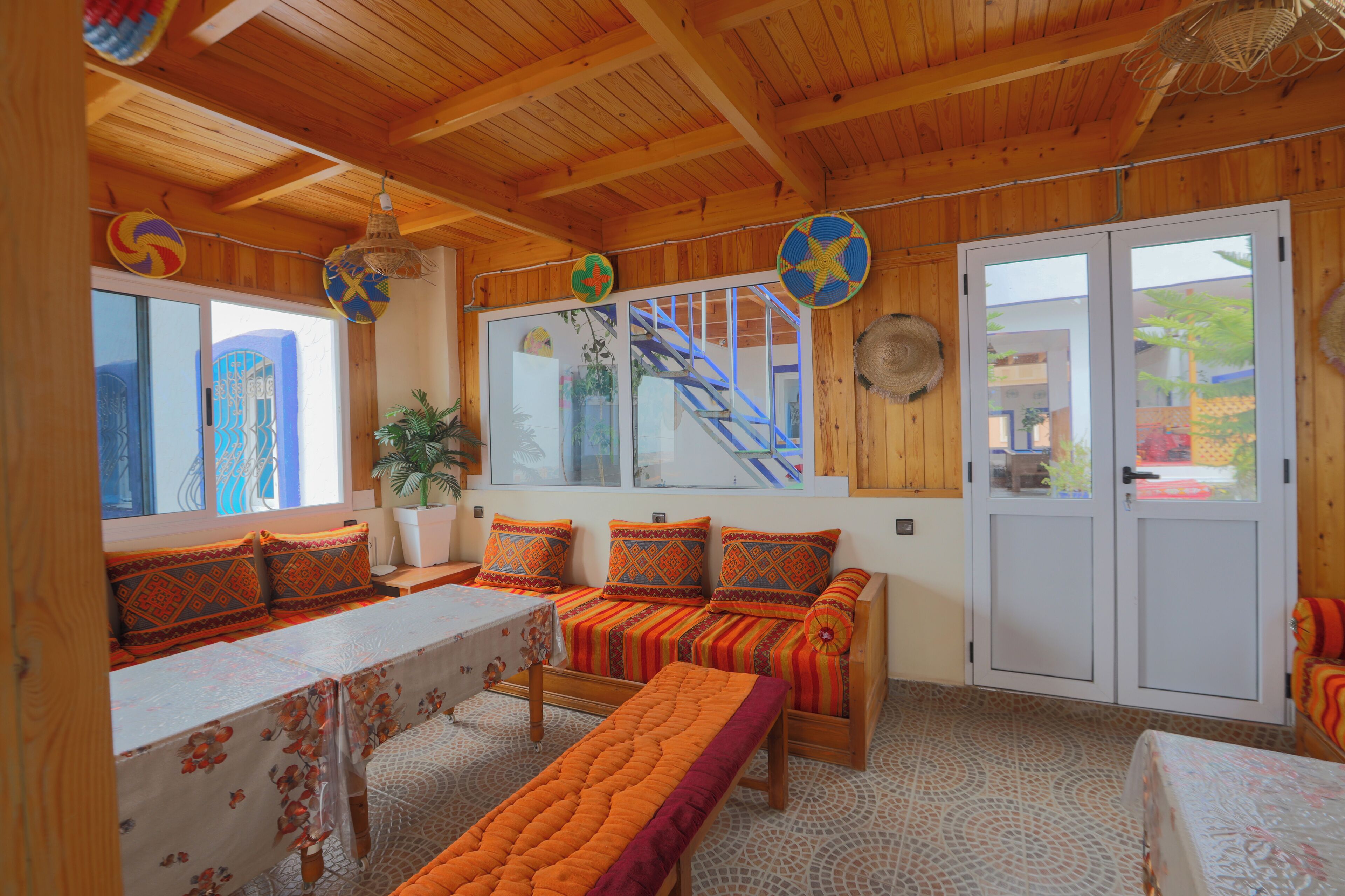 A wooden interior with a sofa set, a dining table, and a bench.