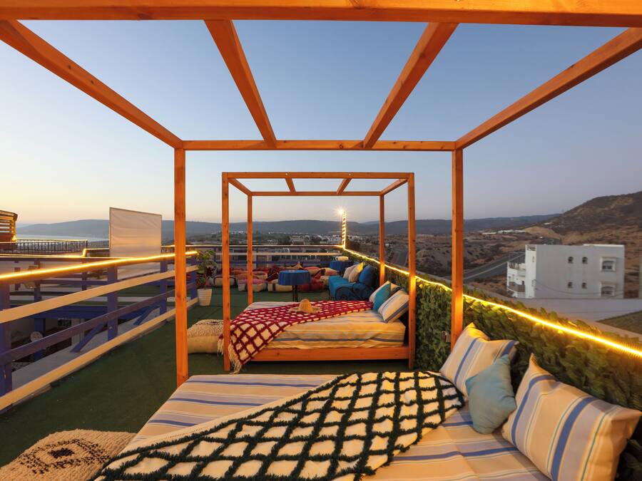 Terraço no telhado com cama, área de estar e vista para a paisagem urbana.