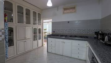 A kitchen with white cabinets, a granite countertop, and a tiled backsplash.