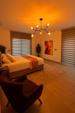 A modern bedroom with a bed, a chair, a floor lamp, and a ceiling light fixture.