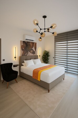 A modern bedroom with a large bed, a black armchair, a chandelier, and a large window with blinds.