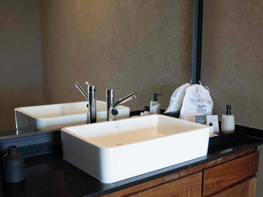 A bathroom with two sinks, a mirror, and a wooden vanity.