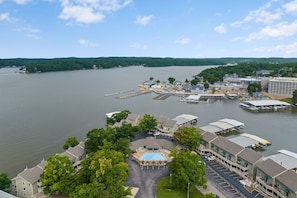 A lakeside hotel with a swimming pool, dock, and parking area. - Lakeside Condo Near Margaritaville w/ Dock, Boat Slip, Pool, & Mini Bar (Osage Beach)