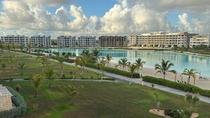A resort with a large pool, multiple buildings, and well-maintained lawns. - Chic Boho Apartment Overlooking Crystal Lagoon (Punta Cana)