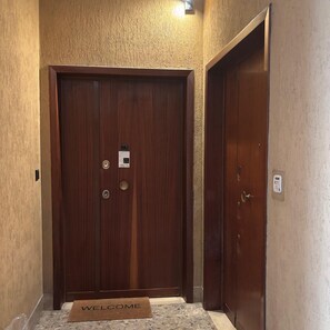Una porta in legno con un tappetino accogliente e un cartello che indica 'Eva Suite'.